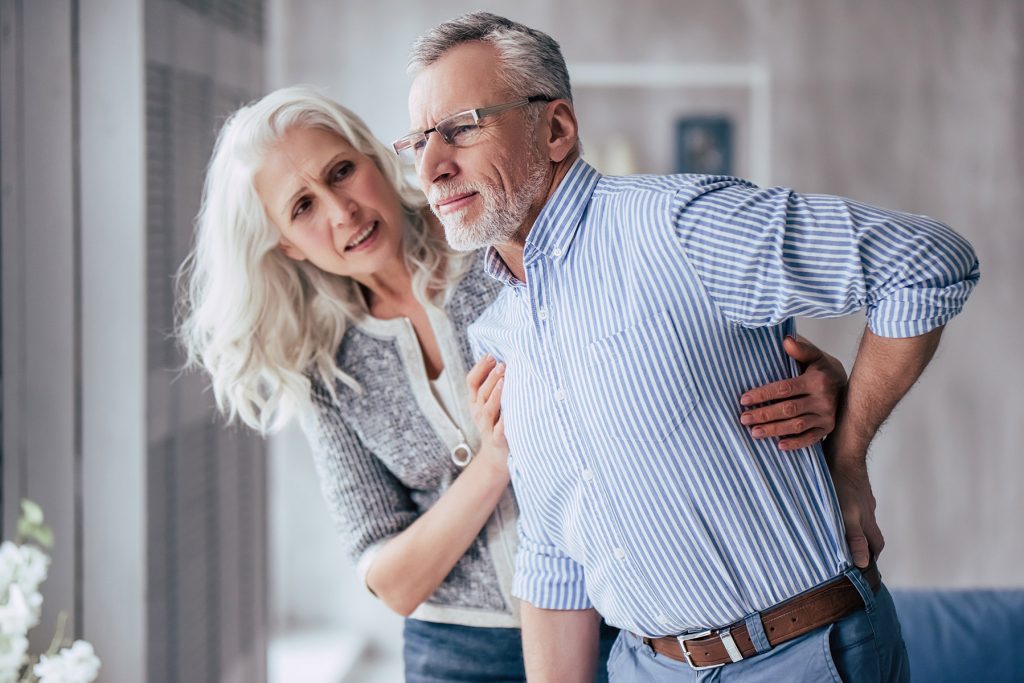 Man Suffering from Pain and Suffering is Assisted by Woman